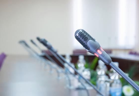 The images shows multiple microphones installed within a long table